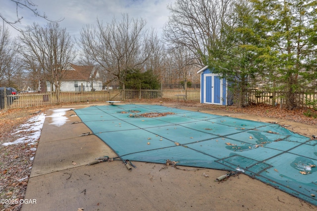 view of pool featuring a patio area, a diving board, and a storage unit