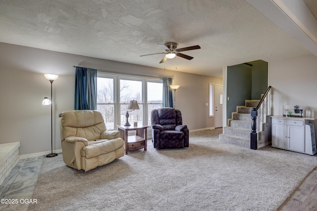 living room with ceiling fan, light carpet, and a textured ceiling