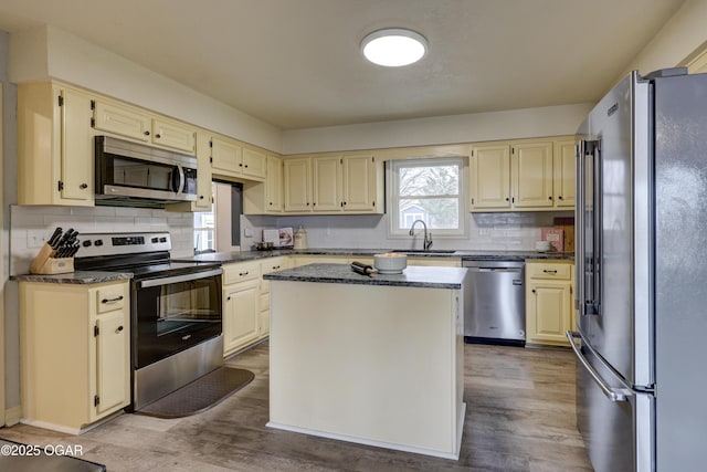 kitchen featuring sink, light hardwood / wood-style flooring, a center island, and appliances with stainless steel finishes