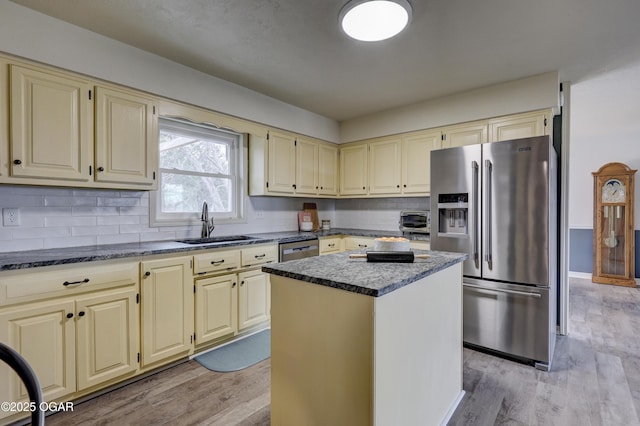 kitchen featuring stainless steel appliances, a center island, sink, and light hardwood / wood-style floors