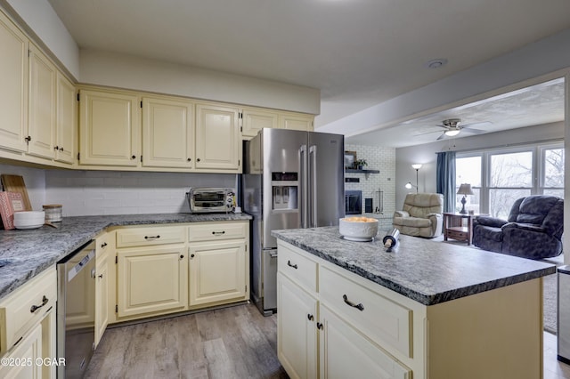 kitchen featuring tasteful backsplash, appliances with stainless steel finishes, cream cabinets, and a kitchen island