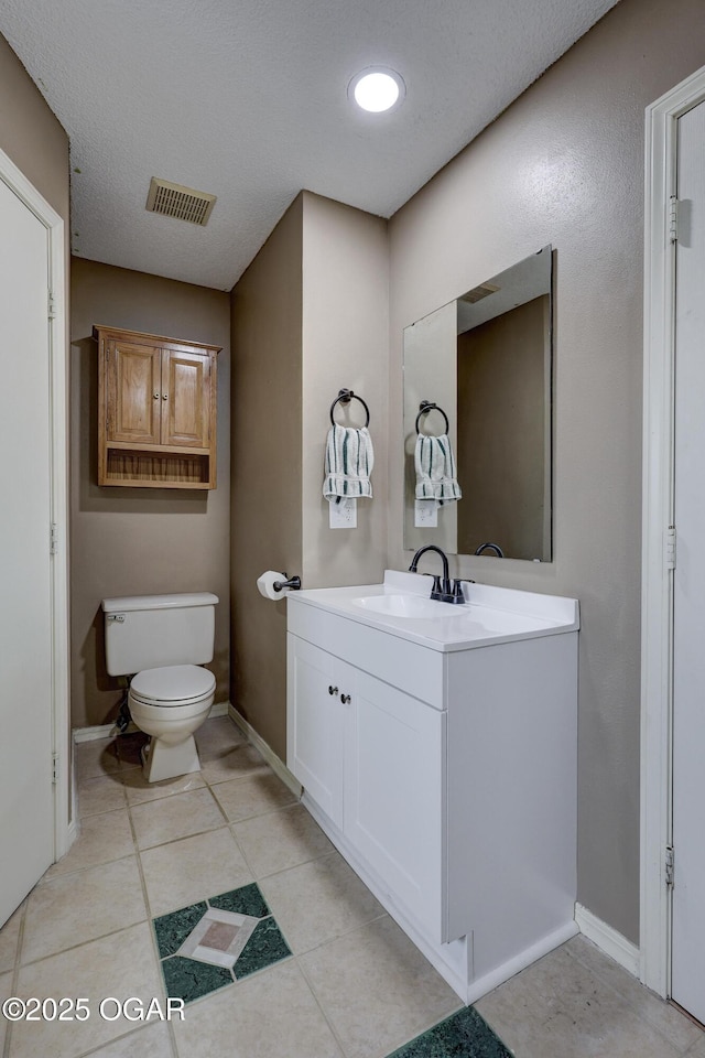 bathroom featuring vanity, tile patterned floors, and toilet