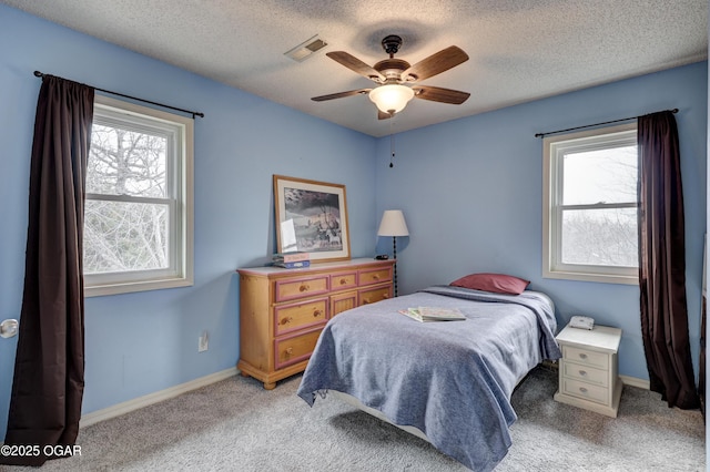 carpeted bedroom with ceiling fan and a textured ceiling