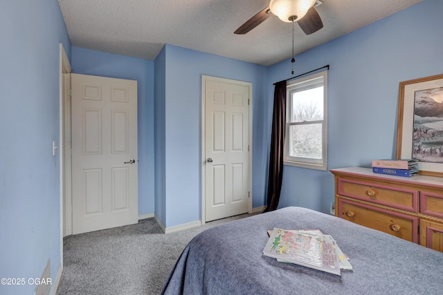 bedroom featuring ceiling fan, light colored carpet, and a textured ceiling