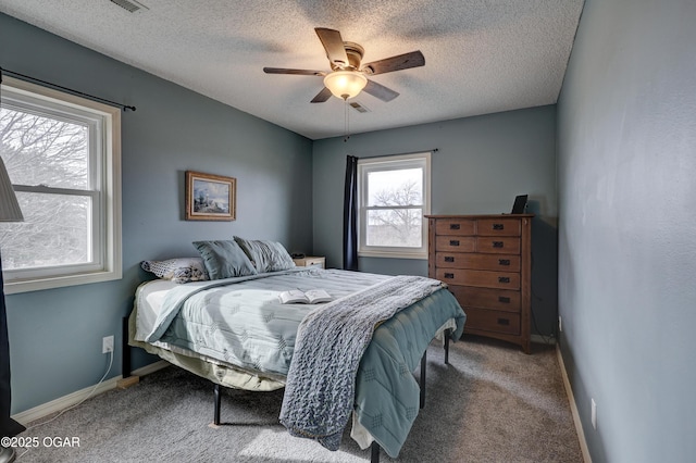 bedroom featuring ceiling fan, carpet floors, and a textured ceiling