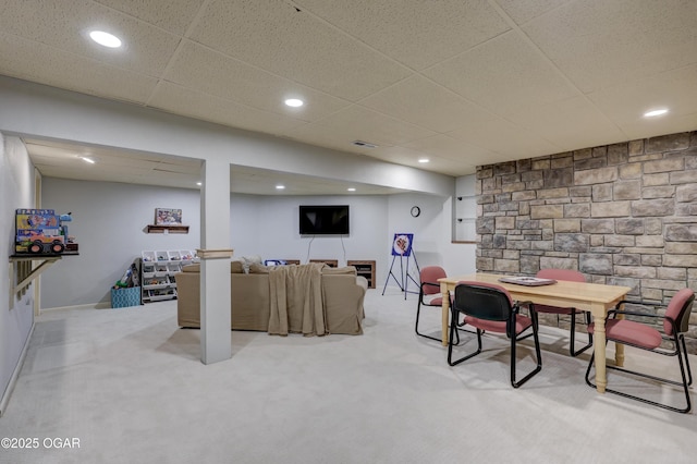 interior space with a paneled ceiling and light colored carpet