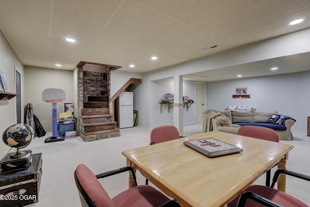 dining room featuring light carpet and a drop ceiling