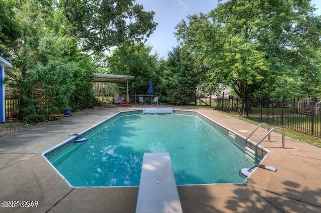 view of swimming pool featuring a diving board and a patio area