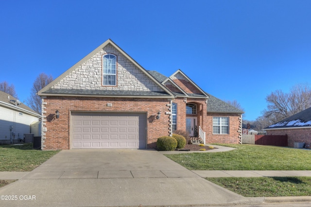 view of front of house featuring a garage, a front yard, and central AC