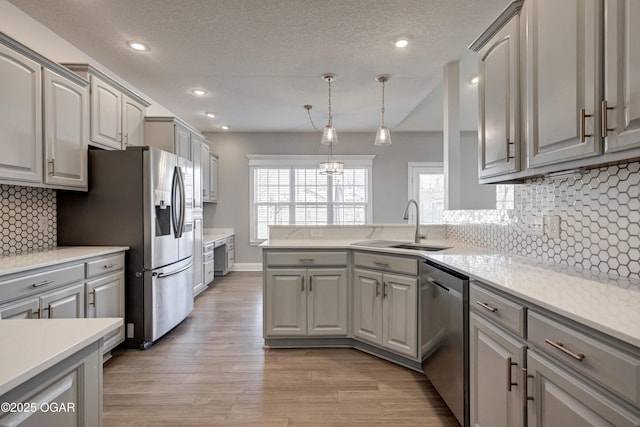 kitchen with stainless steel appliances, gray cabinetry, and sink