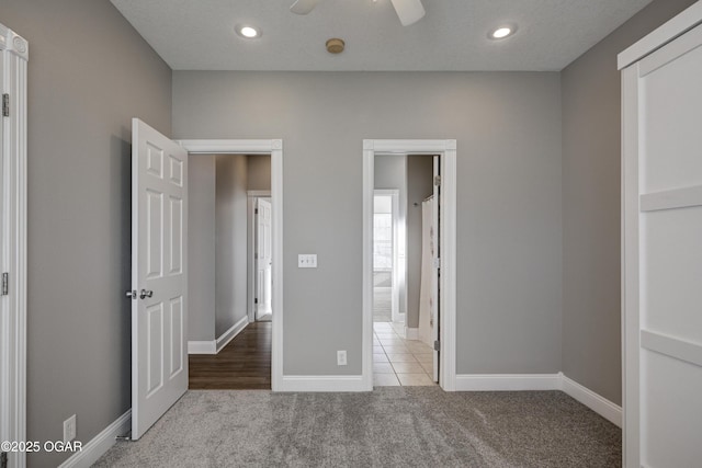 unfurnished bedroom with ceiling fan and light colored carpet