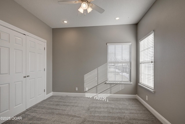 unfurnished bedroom featuring ceiling fan, a closet, and carpet floors