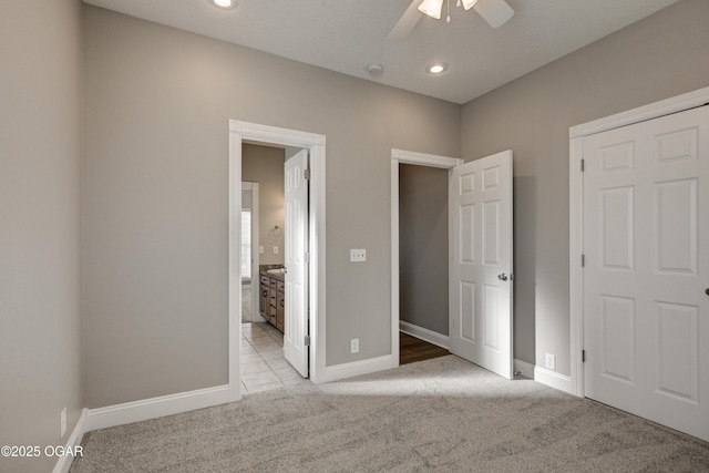 unfurnished bedroom featuring ceiling fan, connected bathroom, and light carpet