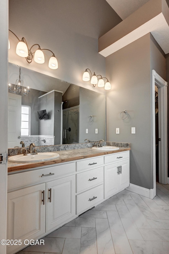 bathroom featuring a shower with shower door, vanity, and an inviting chandelier