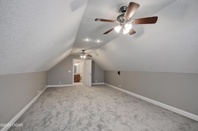 bonus room featuring ceiling fan, a textured ceiling, and vaulted ceiling