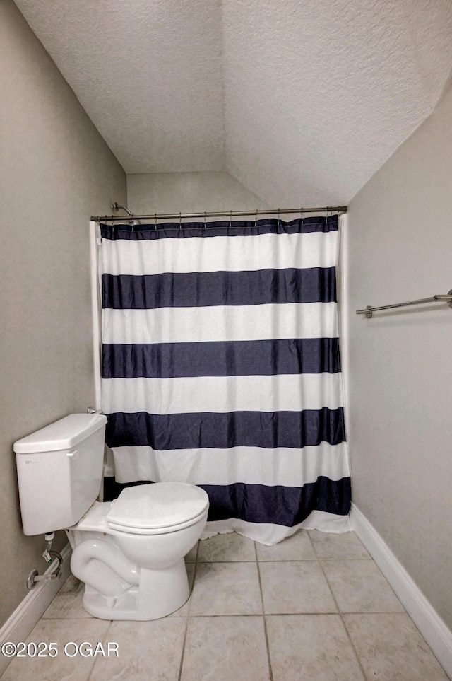 bathroom featuring toilet, walk in shower, vaulted ceiling, tile patterned floors, and a textured ceiling