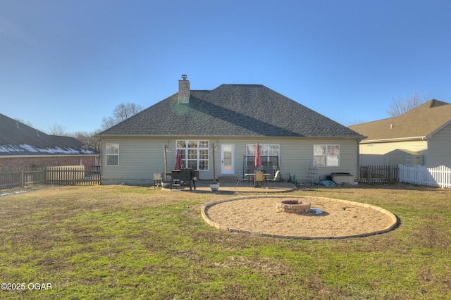 back of house featuring a yard, a patio, and a fire pit