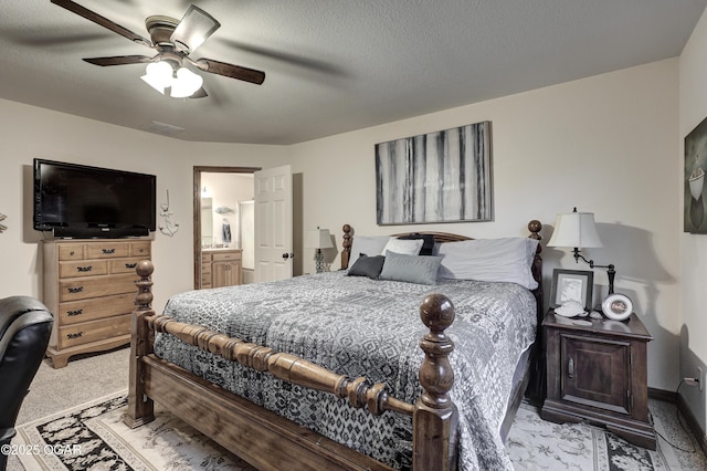 carpeted bedroom featuring ensuite bathroom, a textured ceiling, and ceiling fan