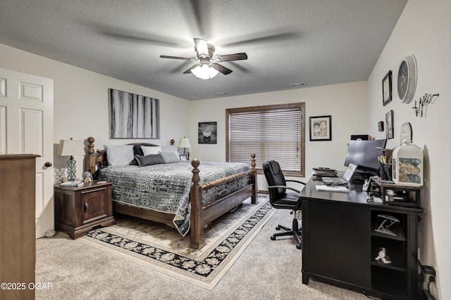 bedroom with ceiling fan, light colored carpet, and a textured ceiling