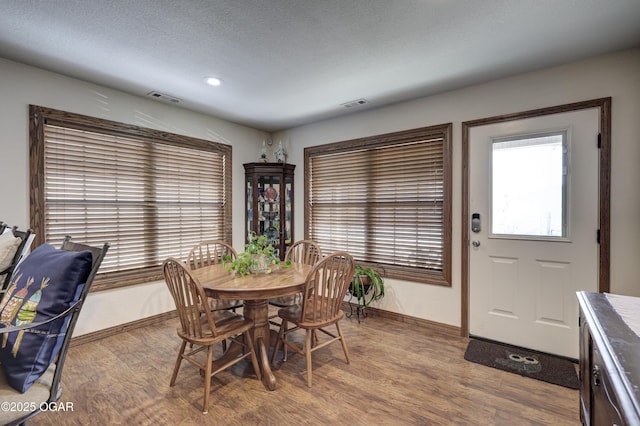 dining space with a textured ceiling and hardwood / wood-style floors