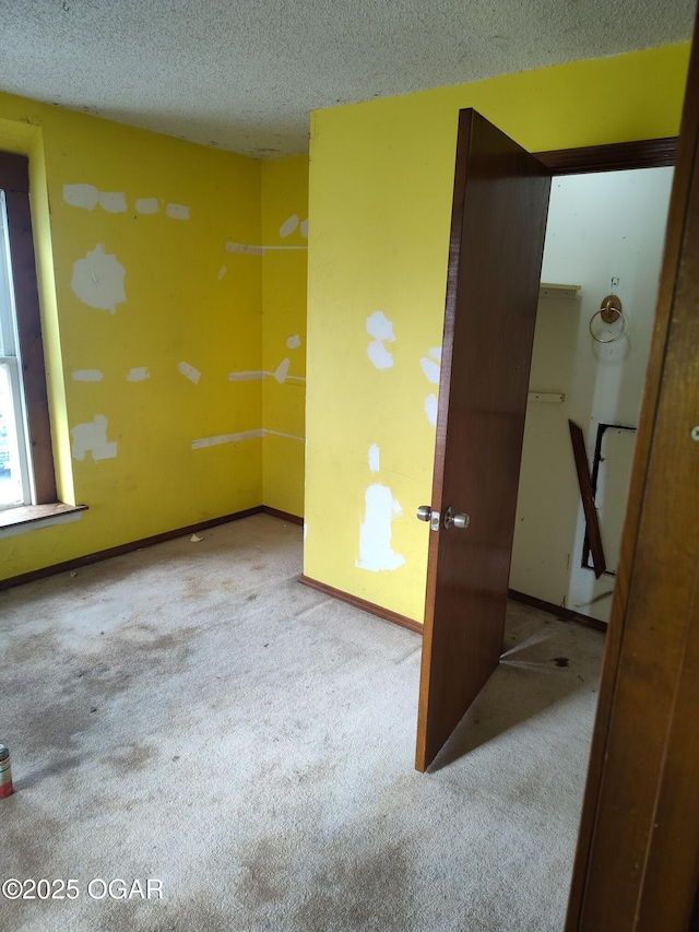 carpeted spare room with a textured ceiling