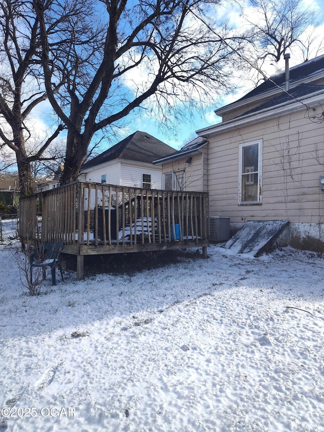 snow covered property with a wooden deck