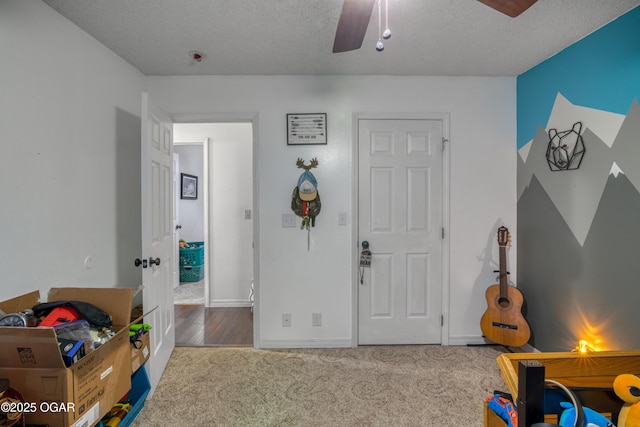 carpeted bedroom with a textured ceiling and ceiling fan