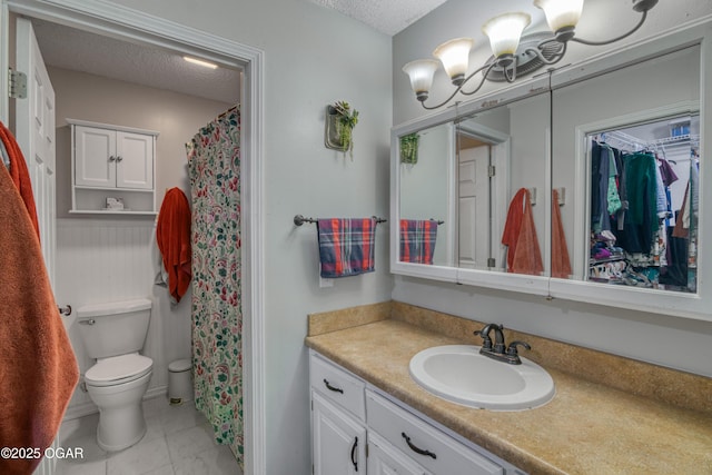 bathroom featuring toilet, vanity, and a textured ceiling