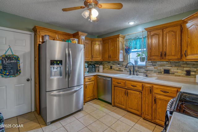 kitchen with a textured ceiling, appliances with stainless steel finishes, tasteful backsplash, sink, and ceiling fan