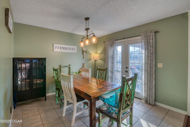 tiled dining space with a textured ceiling and french doors