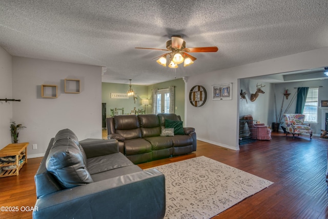 living room with ceiling fan, dark hardwood / wood-style floors, plenty of natural light, and a textured ceiling