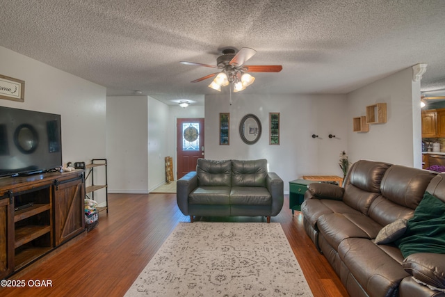 living room featuring ceiling fan, dark hardwood / wood-style flooring, and a textured ceiling