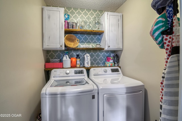 laundry area with cabinets, a textured ceiling, and independent washer and dryer