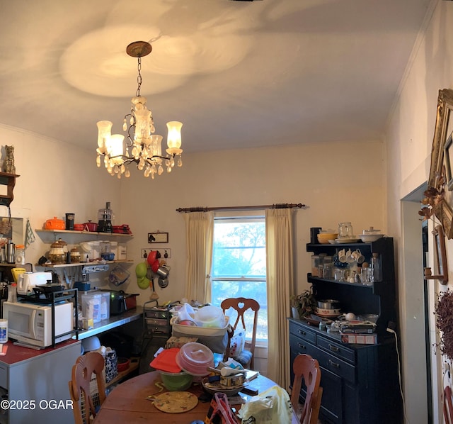 dining area with crown molding and a notable chandelier