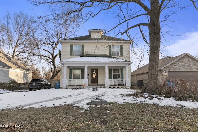 view of property featuring covered porch, a garage, and central air condition unit