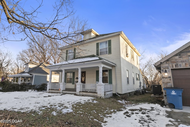 view of front of home featuring covered porch, a garage, and central AC