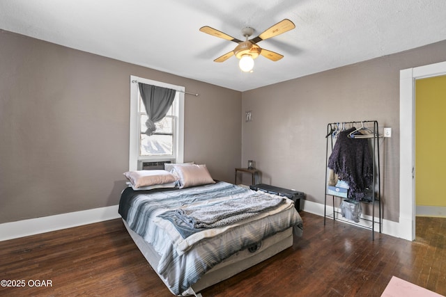 bedroom with ceiling fan, dark wood-type flooring, and a textured ceiling