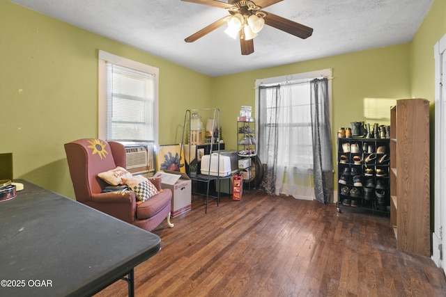 misc room featuring a textured ceiling, dark wood-type flooring, cooling unit, and ceiling fan