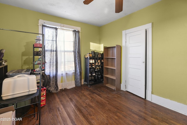 miscellaneous room with ceiling fan and dark wood-type flooring