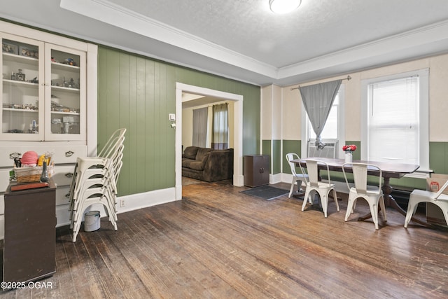 office featuring wooden walls, dark hardwood / wood-style floors, a tray ceiling, a textured ceiling, and ornamental molding