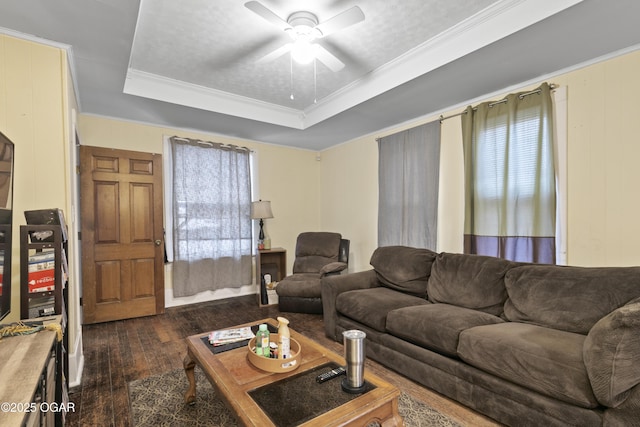 living room featuring ceiling fan, dark hardwood / wood-style flooring, crown molding, and a raised ceiling