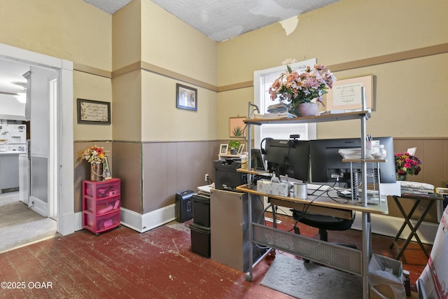 office space with a textured ceiling and wooden walls