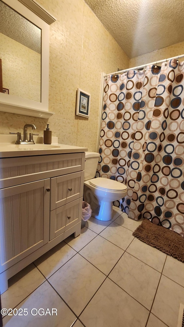 bathroom with a textured ceiling, toilet, tile patterned flooring, and vanity