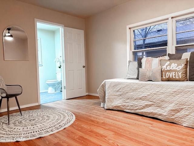 bedroom featuring connected bathroom and hardwood / wood-style flooring