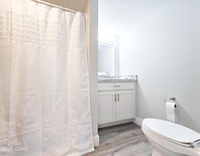 bathroom featuring hardwood / wood-style floors, a textured ceiling, toilet, and vanity