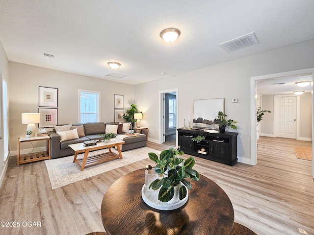 living room featuring light wood-type flooring and a textured ceiling