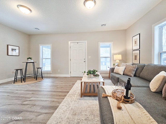 living room featuring light hardwood / wood-style flooring and a textured ceiling