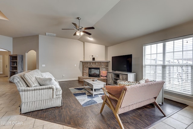 living room with ceiling fan, light tile patterned floors, lofted ceiling, and plenty of natural light