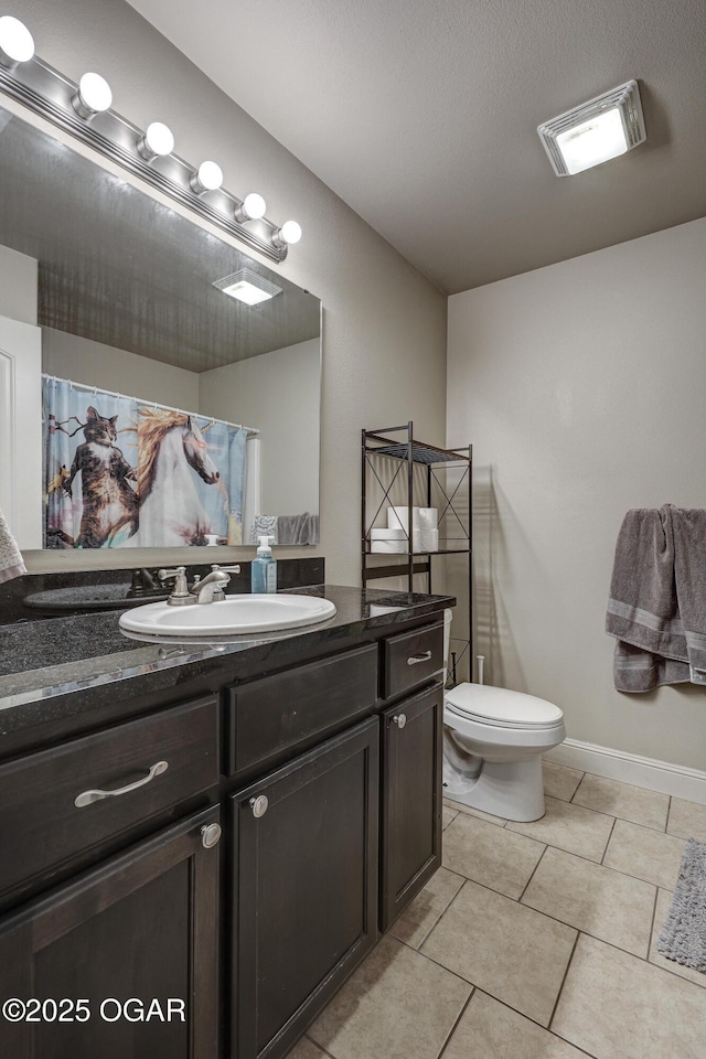 bathroom with tile patterned floors, toilet, vanity, and a textured ceiling