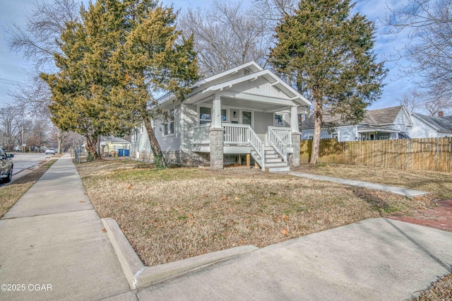 bungalow-style house with covered porch and a front lawn